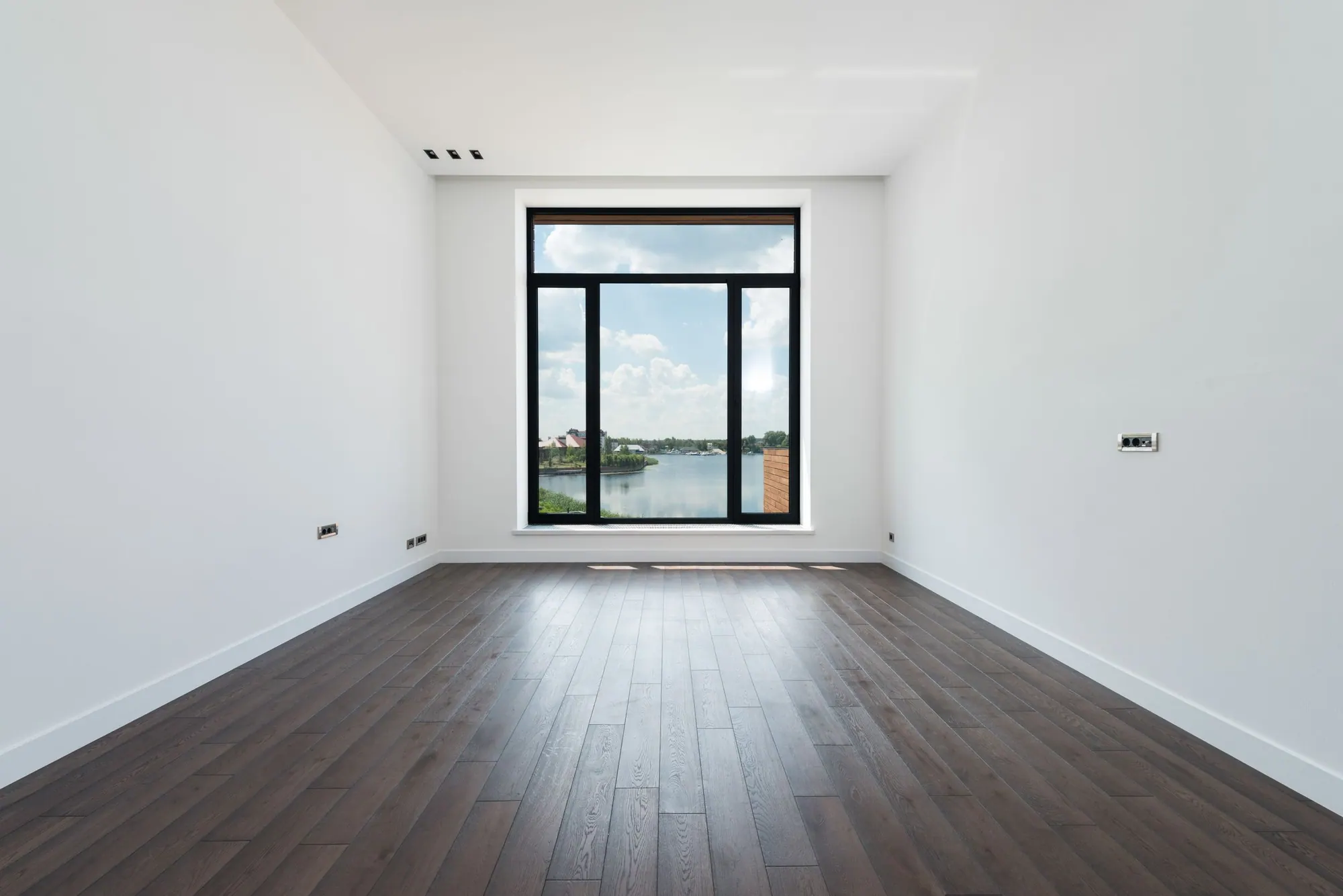 Heller Raum mit Laminatboden und großem Fenster