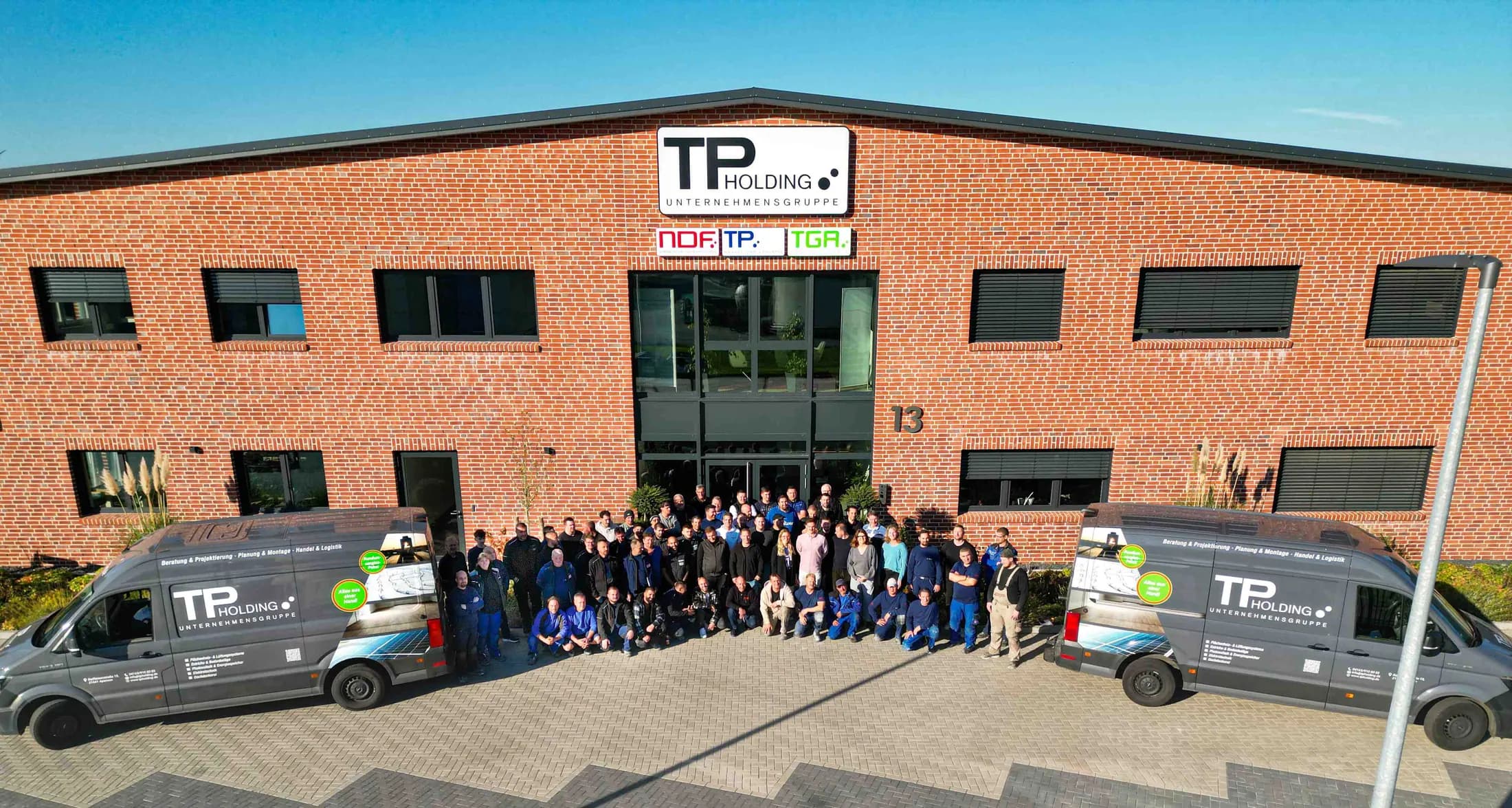 Das Team der TP Holding Unternehmensgruppe vor dem Firmengebäude